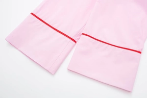 Détail des poignets de pyjama en popeline rose clair avec passepoil rouge et coutures