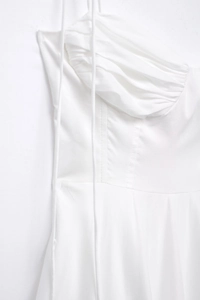 Detail of white poplin dress with structural corset seams and elegant pleated bust design