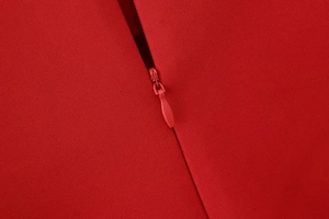 Detailansicht eines versteckten Reißverschlusses an einem roten Kleid mit glattem Stoff