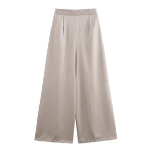 Dettaglio dei pantaloni a gamba larga a vita alta in raso color champagne lucido