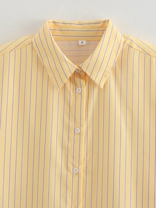 Close-up of a yellow striped shirt collar and white buttons with clear fabric texture