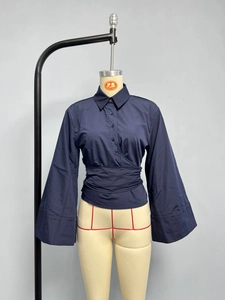 Detail of navy poplin shirt featuring wrap waist tie and dramatic wide flared cuffs