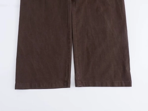 Dettaglio dell'orlo dei pantaloni larghi marrone scuro con tessuto a coste e cuciture