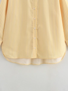 Close-up of yellow striped shirt showing white buttons and curved high-low hemline
