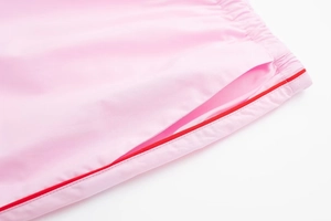 Détail du pantalon de sport rose avec liseré rouge et taille élastique avec poches