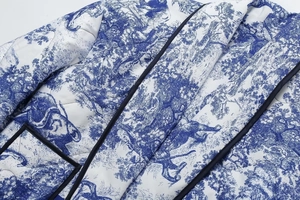 Detailed macro view of diamond-quilted fabric with classic blue and white Toile de Jouy print