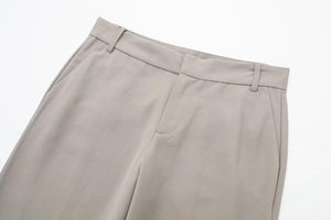 Detail of waist design on gray tailored trousers showing belt loops and side pockets