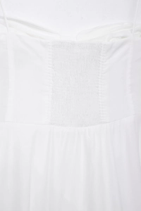 Detailed close-up of white poplin dress featuring back smocking and thin straps