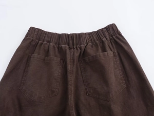 Dettaglio vita elastica e tasche posteriori su pantaloni a gamba larga marrone caffè