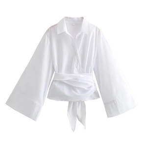 Detail of white wrap poplin shirt featuring a deep V-neckline and waist tie bow detail