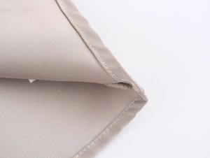 Dettaglio delle cuciture uniformi e della trama diagonale in raso beige fine