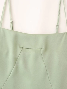 Détail des bretelles réglables et du col carré sur une robe en satin vert menthe