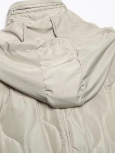 Dettaglio della trapuntatura a onde e cucitura del cappuccio su una giacca beige