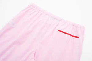 Détail du pantalon de pyjama rose avec taille élastique et poche arrière à liseré rouge