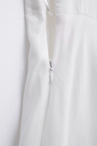 Detailed close-up of a concealed back zipper on a crisp white poplin summer dress