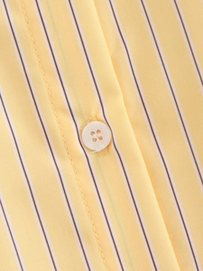 Macro shot of vertical yellow stripes and high-quality button on cotton shirt
