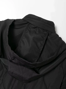 Dettaglio delle cuciture trapuntate e del colletto di una giacca nera imbottita