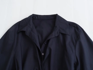 Detailed close-up of navy blue poplin shirt collar and neat button placket quality