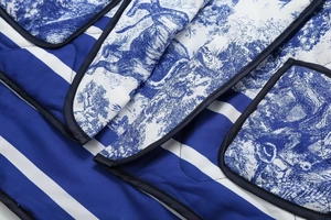 Macro detail of Toile de Jouy print and wide stripes on quilted cotton jacket