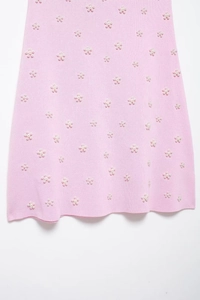 Vue détaillée du tissu en maille rose avec motifs de petites fleurs en perles et texture fine