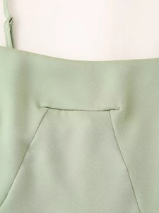 Détail de robe en satin vert menthe avec coutures d'encolure et bretelle réglable
