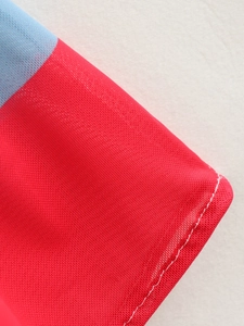 Macro detail of red and blue mesh fabric with professional white double stitching