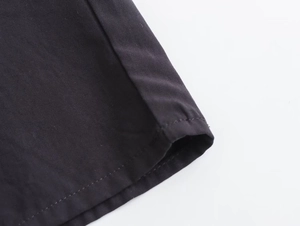 Close-up of clean stitching and smooth woven fabric texture on a black summer dress