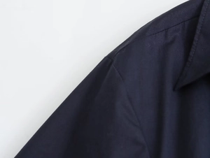 Close-up of navy blue poplin shirt shoulder stitching and collar seam detail