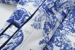 Close-up of quilted floral cotton jacket featuring blue Toile de Jouy print and navy trim