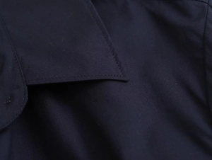 Close-up of navy blue poplin shirt lapel showing high-quality stitching and fabric texture