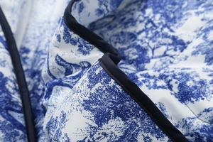 Detailed view of floral blue and white print fabric with black piping on the jacket
