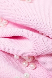 Détail de la maille rose avec des ornements de perles nacrées élégantes pour femmes