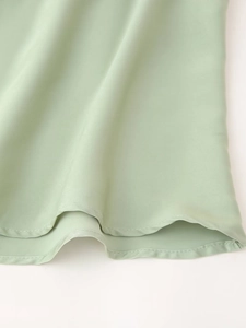 Détail de l'ourlet à double couture sur la robe en satin vert menthe à texture lisse