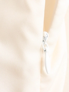 Detailed macro view of cream-colored woven fabric with a smooth hidden teardrop zipper