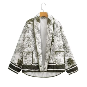 Close-up of quilted floral jacket featuring landscape print and green ribbed trim
