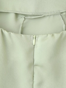 Détail de la fermeture éclair invisible et des coutures fines sur la robe en satin vert