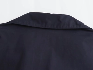 Detail of the navy blue poplin shirt collar with precise stitching and fabric texture