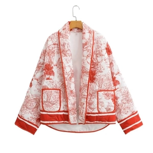 Detail of red toile de jouy printed quilted jacket with front pockets and trim