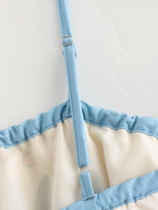 Detail view of adjustable spaghetti straps with silver metal buckles on a floral maxi dress