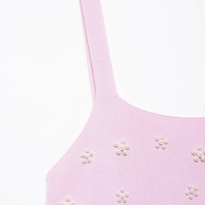 Haut en tricot rose orné de fleurs en perles artificielles sur le détail du décolleté