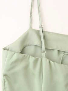 Détail des bretelles réglables et du tissu satiné sur une robe d'été vert menthe