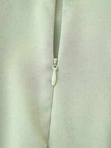 Détail du zip invisible sur une robe en satin vert menthe élégante pour femmes