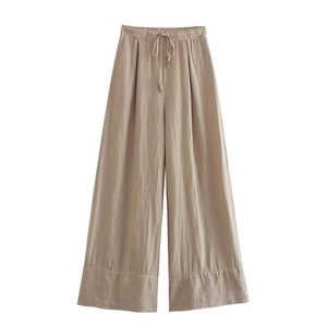 Détail du pantalon large en lin kaki avec taille élastique à cordon et tissu texturé