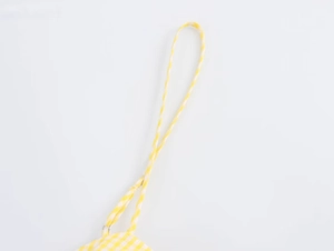 Detail view of yellow gingham dress fabric with adjustable strap and metal ring buckle