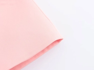 Dettaglio del tessuto rosa che mostra la trama fine e la qualità del materiale