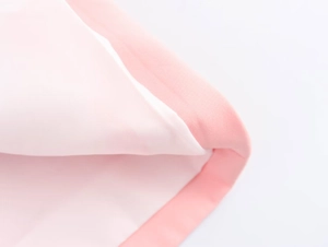 Vista macro dettagliata che mostra la trama del tessuto rosa e bianco e le cuciture