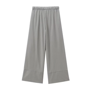 Detail view of light grey wide-leg trousers with elastic waistband and seam detail