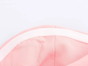 Dettaglio della cucitura interna sulla fascia in tessuto rosa con fodera in cotone bianco