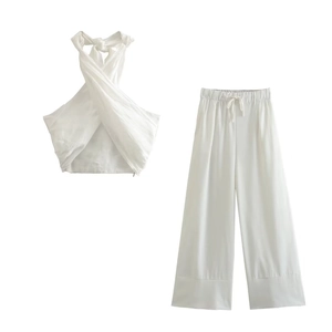 Flat lay of white halter neck wrap top and matching wide leg trousers in linen fabric