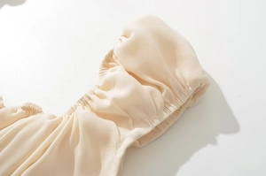 Macro detail of beige puff sleeves with elastic cuffs and textured chiffon fabric